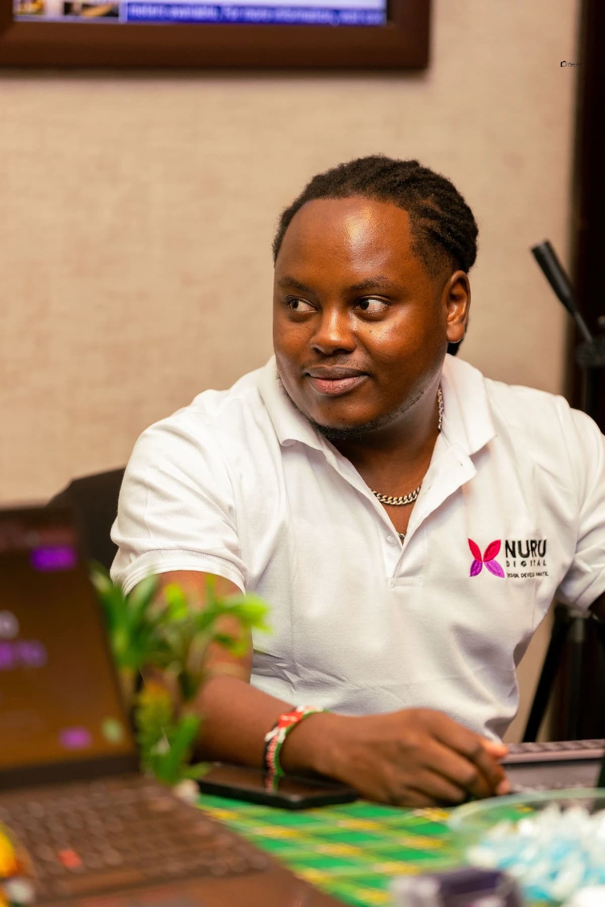 Kelvin Wambugu, founder of Nuru Digital, at work in a white Nuru polo shirt